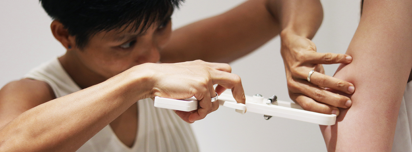 nutritionist measuring client's body fat