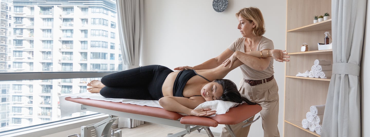 osteopath stretching client's leg