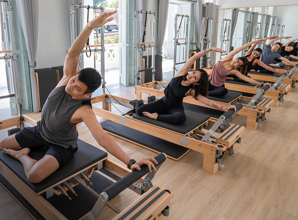 people doing pilates exercises on reformers