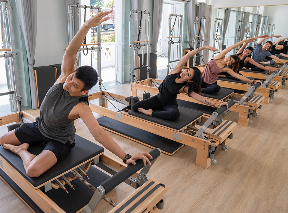  people doing pilates exercises on reformers