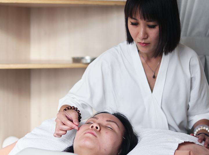 traditional chinese medicine doctor performing acupuncture on patient