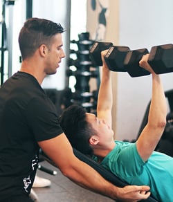 trainer and client doing weight training