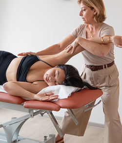 osteopath stretching client's leg